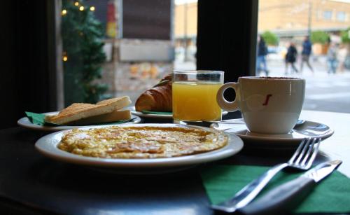 een tafel met een bord eten en een kop sinaasappelsap bij B&B La Residenza Dell'Orafo in Florence