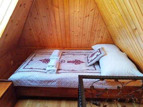 a small bed in a wooden attic room at Willa Tatrzański Zomecek in Kościelisko