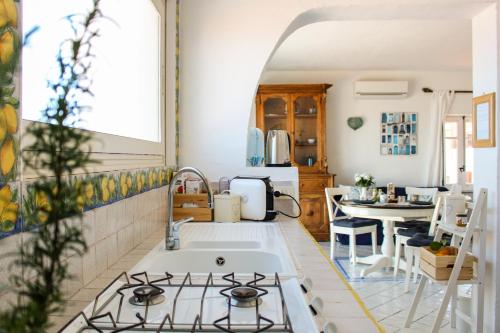 a kitchen with a sink and a stove at Azzurro B&B in Cefalù