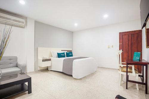 a white bedroom with a bed and a couch at Ayenda Hotel Carivdi in Sincelejo