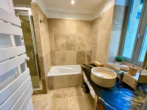 ein Badezimmer mit Badewanne, Toilette und Waschbecken in der Unterkunft Maison de Roche - Uzès Centre historique La Fenestrelle in Uzès