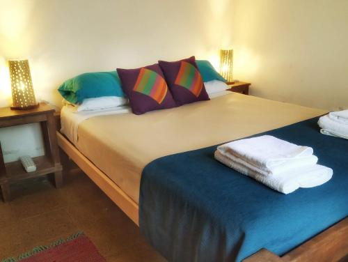 1 dormitorio con 2 camas, toallas y mesa en Casa Suyay en Tilcara
