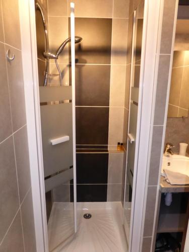 une douche avec une porte vitrée dans une salle de bain dans l'établissement studio Morillon village, à Morillon