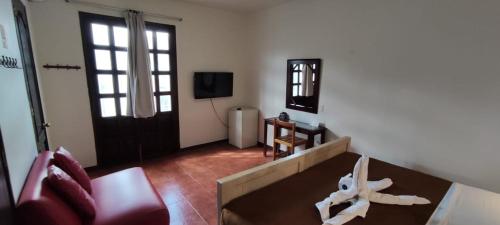 a living room filled with furniture and a tv at Hostal de Las Américas in Oaxaca City