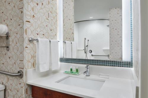a bathroom with a white sink and a mirror at Holiday Inn - Gulfport-Airport, an IHG Hotel in Gulfport