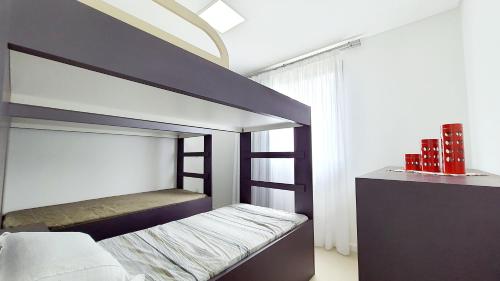 a bedroom with a bunk bed with a ladder at Residencial Renata - Apartamento na Praia de Palmas - 3 dormitórios a 300m da Praia in Governador Celso Ramos