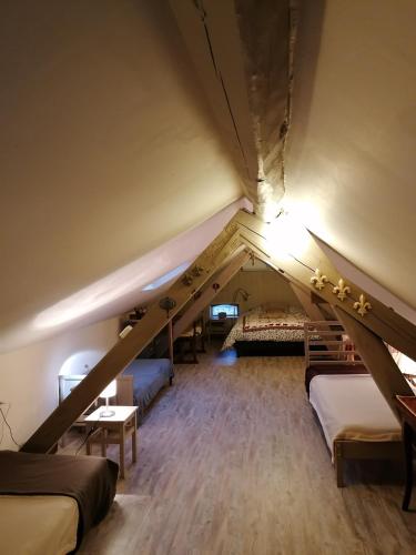 Cette chambre mansardée dispose de lits et d'un escalier. dans l'établissement aux coeurs de l'atelier, à Menars