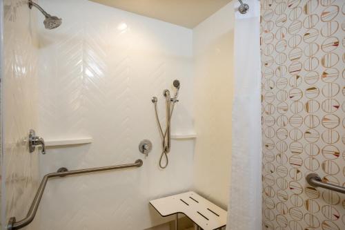 a white bathroom with a shower and a sink at Holiday Inn - Gulfport-Airport by IHG in Gulfport
