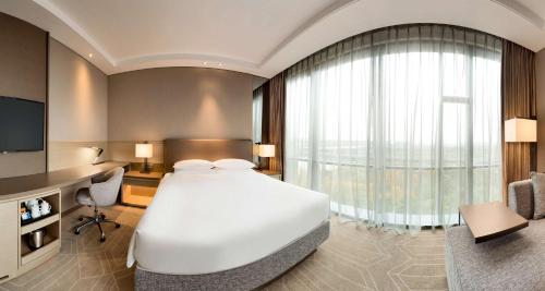 a bedroom with a large white bed and a television at Hyatt Place Shanghai Hongqiao CBD in Shanghai