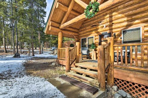 a log cabin with a porch and a wooden stairway at Remodeled Fairplay Log Cabin with Wood-Burning Sauna in Fairplay