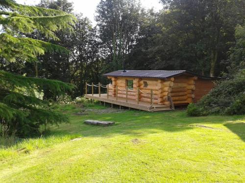 a log cabin with a porch in a yard at Lake District Log Cabins in Broughton in Furness