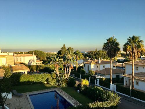 Blick auf ein Haus mit einem Pool und Palmen in der Unterkunft Villa Med in Albufeira