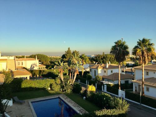 a view of a house with a swimming pool and palm trees at Villa Med - private pool, garden, sun all day, stunning views in Albufeira