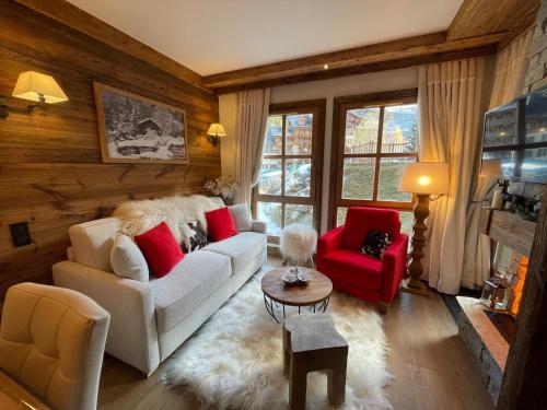 een woonkamer met een witte bank en rode stoelen bij Arc 1950 appt luxe 2-4pers -skis aux pieds-SPA-piscines intérieure et extérieure-sauna-hammam in Arc 1950