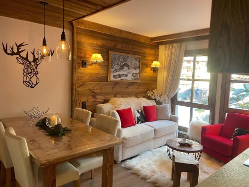 un salon avec une table et un canapé dans l'établissement Arc 1950 appt luxe 2-4pers -skis aux pieds-SPA-piscines intérieure et extérieure-sauna-hammam, à Arc 1950