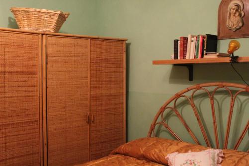 een slaapkamer met een houten kast en een stoel bij Appartamento in Borgo storico (San Vito Romano) in San Vito Romano