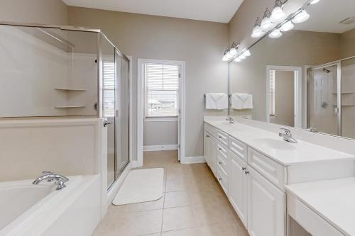 a white bathroom with two sinks and a mirror at Windswept by Meyer Vacation Rentals in Gulf Shores