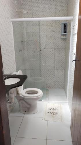 a bathroom with a toilet and a glass shower at Maravilhosa casa na praia do Francês in Praia do Frances