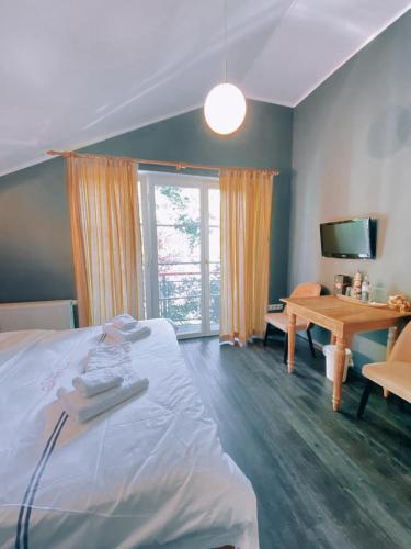 a bedroom with a bed and a desk and a television at Villa Seebach in Boltenhagen