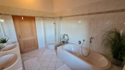 a bathroom with a tub and a toilet and a sink at Schönes Ferienhaus am Herrenberg in Prien am Chiemsee