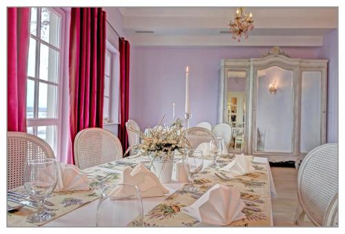 a dining room with a table with white chairs at Miód Lawenda in Biardy