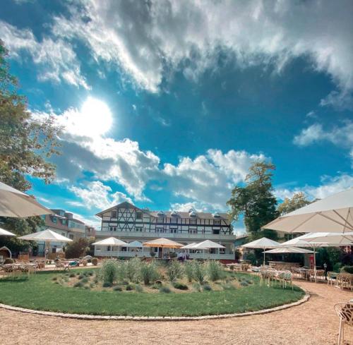 a resort with tables and umbrellas in a courtyard at Villa Seebach in Boltenhagen