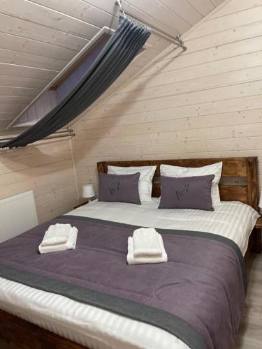 a bedroom with a large bed with two towels on it at Villa Затишна de luxe in Mykulychyn