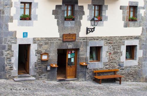 
a building with a bench and a window at Hostal Musunzar in Leitza
