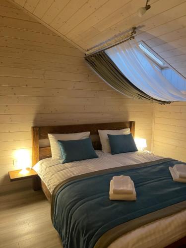 a bedroom with a large bed with a window at Villa Затишна de luxe in Mykulychyn