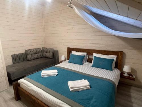 a bedroom with a bed and a couch in a room at Villa Затишна de luxe in Mykulychyn