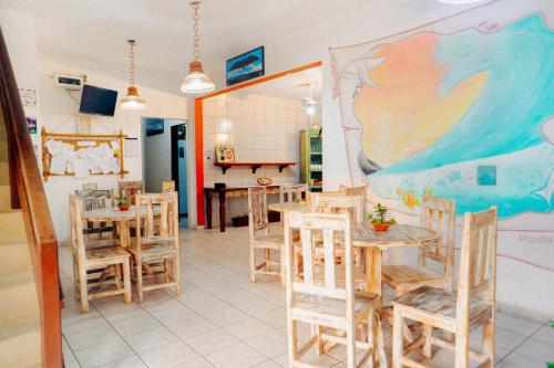a room with tables and chairs and a painting on the wall at Pousada Vida Farol in Farol de Santa Marta