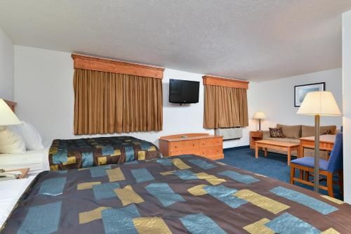 ein Hotelzimmer mit einem Bett und einem Wohnzimmer in der Unterkunft Corn Palace Inn in Mitchell