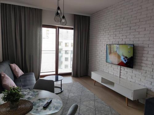 salon z telewizorem na murze w obiekcie Lovely Apartment vis-a-vis Medicover and Paley Institute w Warszawie