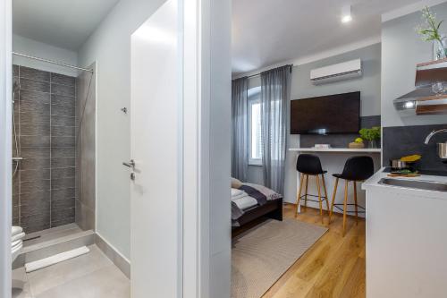 uma casa de banho com uma cabina de duche ao nível do chão ao lado de uma cozinha em Adria Square Studios em Rijeka