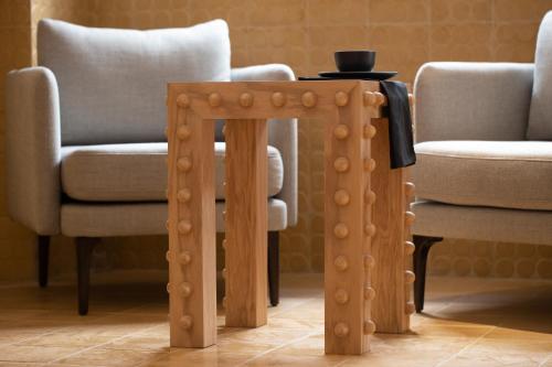 William Hotel Boutique De Diseño في تاكسكو دي الاركون: طاولة خشبية في غرفة معيشة مع كرسيين