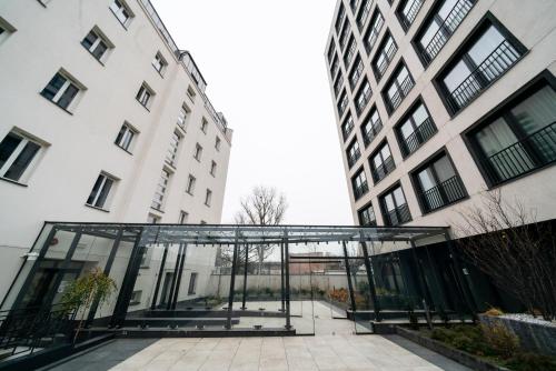 a glass structure in front of two buildings at Hotel Tulip Residences Warsaw Targowa in Warsaw