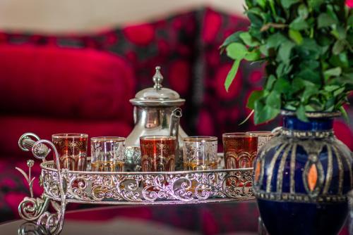 a tray with glasses and a tea pot and a vase at Riad Abjaou in Marrakech