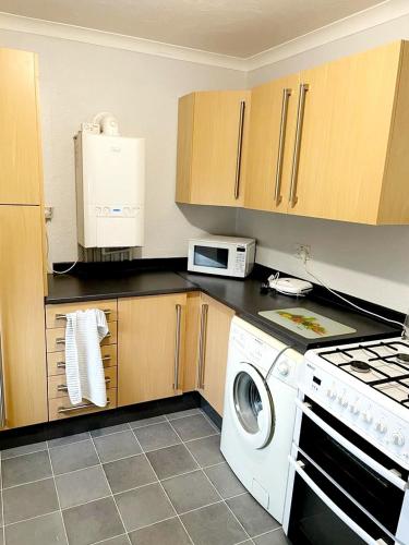 a kitchen with a stove and a washer at Two Bedroom Apartment, 10 Mins From Bexhill Seafront, Social Club On Site in Bexhill