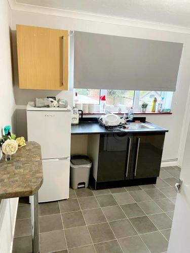a kitchen with a black counter and a white refrigerator at Two Bedroom Apartment, 10 Mins From Bexhill Seafront, Social Club On Site in Bexhill