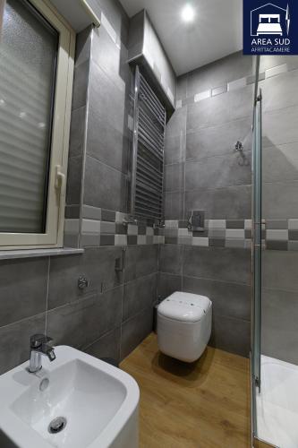 a bathroom with a white sink and a toilet at Area Sud in Canicattì