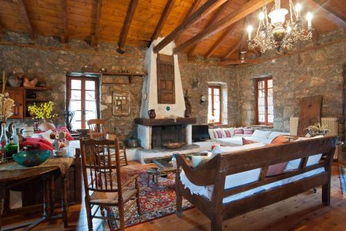a living room with a couch and a table with chairs at MARIOLATA STONE HOUSE in Lílaia