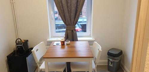 a dining room table with two chairs and a window at Pension Italia in Lübeck