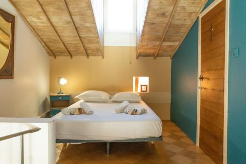 une chambre avec un lit dans une pièce avec des plafonds en bois dans l'établissement HYPERCENTRE 10 MIN DE LA GARE D'AVIGNON - Appartement charmant et lumineux, à Avignon