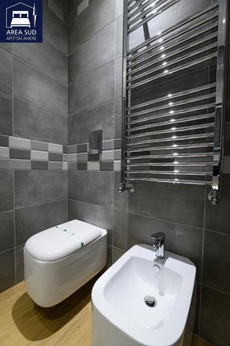 a bathroom with a white sink and a toilet at Area Sud in Canicattì