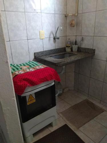 a small kitchen with a sink and a stove at Apto flat Antônio in Campos dos Goytacazes