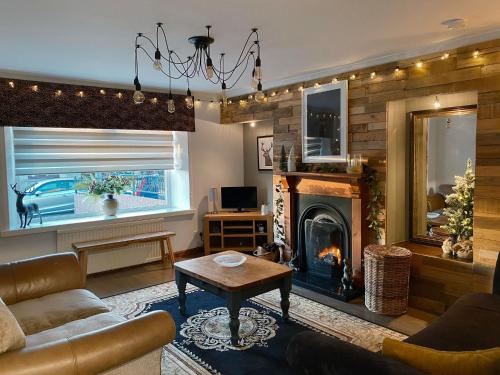 a living room with a couch and a fireplace at Claire's Townhouse, Aberdeenshire, 3 bedrooms in Oldmeldrum