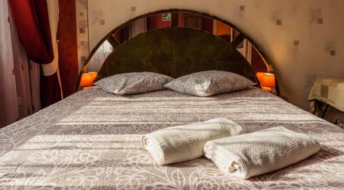 a bed with two pillows on top of it at Pālena apartamenti in Tērvete