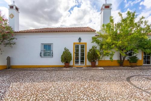 a white building with a clock on top of it at Monte da Japonica in Redondo