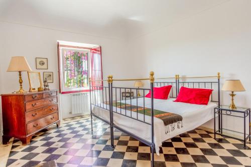 a bedroom with a bed with red pillows and a dresser at Monte da Japonica in Redondo