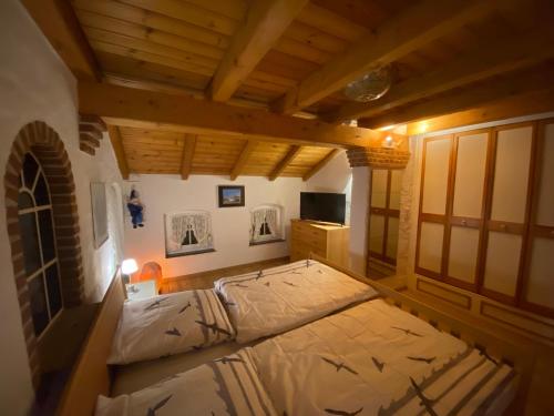 - une chambre avec un lit dans une pièce dotée de plafonds en bois dans l'établissement Lindenhuus-Urlaub unter einem Teilreetdach-Terrasse - Nahe Norden-Norddeich, à Osteel